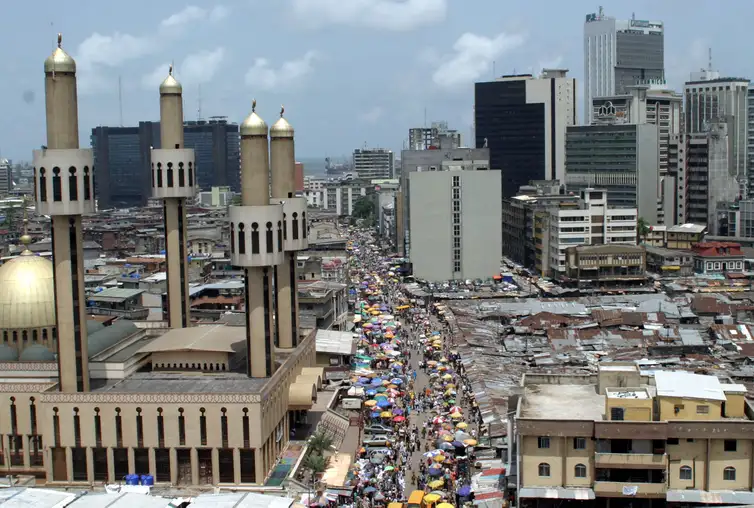 People and traffic move along a busy street in Lagos, Nigeria, May 24,2005. The African Union (AU) celebrates Africa Day on Wednesday May 25, marking the anniversary of the founding in 1963 of the Organization of African Unity, replaced in 2002 by the AU as the driving force behind the struggle for peace, democracy, development, human rights and good governance on the worlds poorest continent. REUTERS/George Esiri FOR/LA